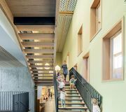 Une salle communale glissée sous une école en Haute-Savoie, par Nunc architectes