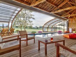 Un abri de piscine en bois ferme un hangar pour une piscine dedans/dehors