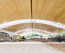 Une structure en bois discrète sous une toiture courbe végétalisée