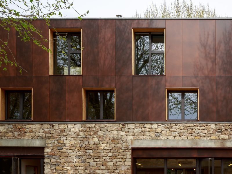 Un bâtiment technique en bois inséré dans une ancienne grange