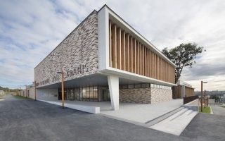 Un bâtiment scolaire joue de ses menuiseries pour accentuer sa verticalité